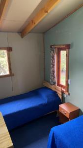 1 Schlafzimmer mit 2 Betten und einem Fenster in der Unterkunft Cabañas parcela el ciprés in Melipeuco