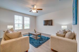 a living room with two chairs and a tv at Chic Mesquite Townhome about 11 Mi to Downtown Dallas! in Mesquite