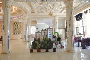 um átrio com colunas e plantas num edifício em Evraziya business hotel em Bukhara