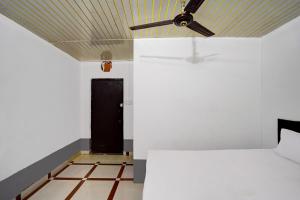 a room with a ceiling fan and a black door at OYO Silver Spoon Hotel And Restaurant in Meerut