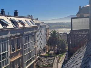 vistas a una ciudad con edificios y palmeras en EnFOZ PLAYA PISCINA Y PARKING, en Foz