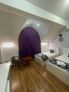 um quarto com duas camas e uma mesa em Evraziya business hotel em Bukhara