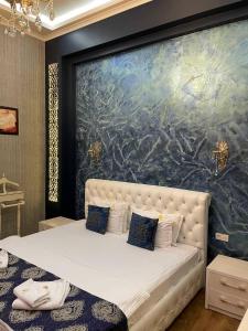 um quarto com uma grande pintura atrás de uma cama em Evraziya business hotel em Bukhara