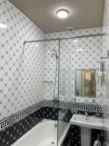uma casa de banho com um chuveiro, uma banheira e um lavatório. em Evraziya business hotel em Bukhara