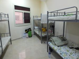 a room with three bunk beds and a window at B&B Hostel in Dubai