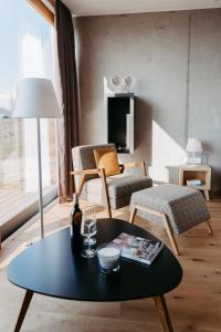 a living room with a table and a chair at RELAX APARTMENTS Hochgraßnitzberg in Spielfeld