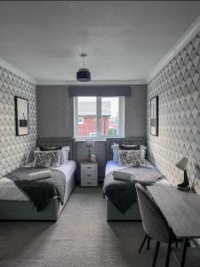 een slaapkamer met twee bedden en een tafel en een tafel sidx sidx sidx bij 5 Min Away From City Centre in Manchester