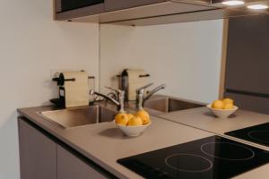 a kitchen with a sink and two bowls of oranges at RELAX APARTMENTS Hochgraßnitzberg in Spielfeld