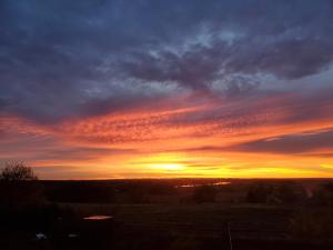 ein Sonnenuntergang auf einem Feld bei bewölktem Himmel in der Unterkunft OK Relax in Rybaki