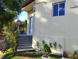 a white house with stairs and a window at Apartamento Inteligente in Japaratinga