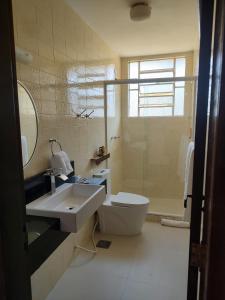 uma casa de banho com um lavatório, um WC e um chuveiro em Pousada Granja Santa Barbara em Petrópolis