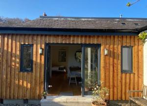 a small wooden house with a sliding glass door at City Central Quiet Garden Studio with Free Parking in Inverness