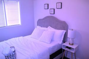 a bedroom with a bed with white sheets and pillows at Cozy-2bedroom in Oakville in Oakville