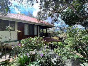 a house with a balcony and some plants at Hotel Villas de la Colina in Atenas