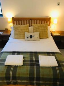 a bedroom with a large bed with two pillows at City Central Quiet Garden Studio with Free Parking in Inverness