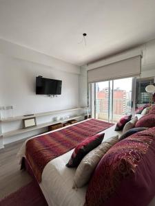 een slaapkamer met een groot bed en een flatscreen-tv bij Ole Towers Apartment in Barrio Norte in San Miguel de Tucumán