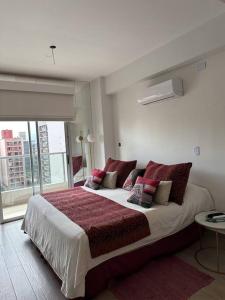 een slaapkamer met een groot bed met rode kussens bij Ole Towers Apartment in Barrio Norte in San Miguel de Tucumán