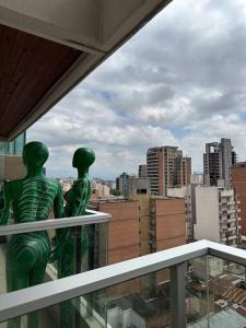 twee groene standbeelden bovenop een gebouw bij Ole Towers Apartment in Barrio Norte in San Miguel de Tucumán