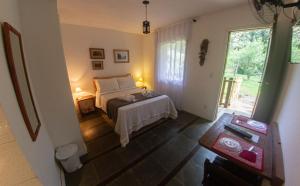 1 dormitorio con cama y ventana grande en Country Inn, Suites & Condo en São Pedro da Serra