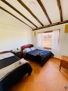 1 dormitorio con 2 camas y ventana en Celestial de la villa, en Villa de Leyva