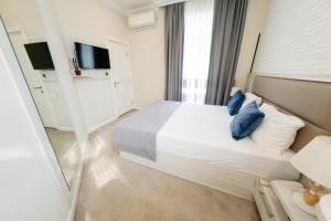 a bedroom with a large white bed with blue pillows at Zimmer Boutique Hotel in Baku