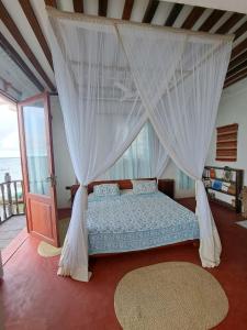 a bedroom with a bed with a canopy at Pwani House - Lamu Seafront in Lamu