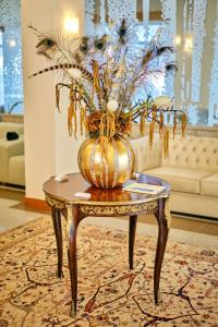 a vase on a table with a plant on it at Hotel O Guerreiro in Ponte da Barca