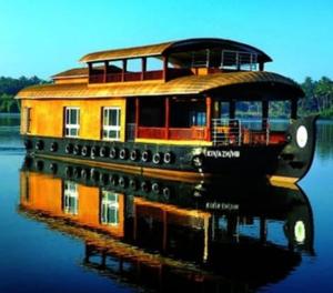 a boat on the water with its reflection in the water at Spice coast cruise in Kokkānisseri