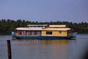 a yellow and blue boat on the water at Spice coast cruise in Kokkānisseri