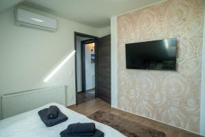 a bedroom with a flat screen tv on a wall at Ciao Lilla Apartman in Keszthely