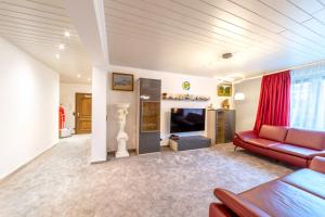 ein Wohnzimmer mit einem roten Sofa und einem TV in der Unterkunft PMC Business Apartments in Rüsselsheim
