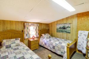 2 camas en una habitación con paneles de madera en Charming Cabin in Mountain View with Deck!, en Mountain View