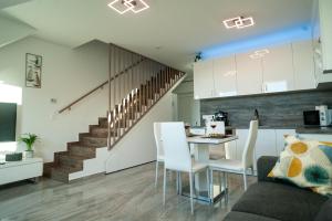 a kitchen and a living room with a table and chairs at Ciao Lilla Apartman in Keszthely