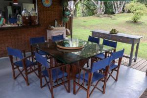 una mesa de comedor con sillas azules alrededor en Ilha privativa - Rio Paraguaçu, en Cachoeira