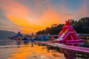 eine Gruppe aufblasbarer Rutschen im Wasser bei Sonnenuntergang in der Unterkunft เดอะวอเตอร์ปาร์ครีสอร์ท- The Water Park Resort in Ban Laem Mong Khoi