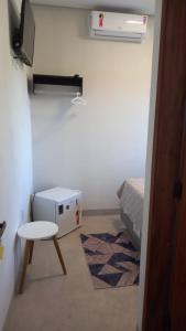 a small room with a bed and a table and a heater at Condomínio Golden Goes in Porto Seguro