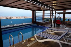 a swimming pool with a chair and a table and avisor at شقق الماسة التاج للشقق الفندقية in Hail