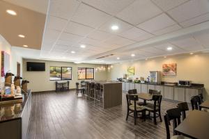 a waiting room with tables and chairs in a restaurant at Sleep Inn & Suites North Mobile Saraland in Saraland