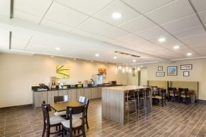 a restaurant with tables and chairs and a bar at Sleep Inn & Suites North Mobile Saraland in Saraland