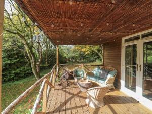 a porch with a couch and chairs on a deck at Pear Tree Lodge in Langport