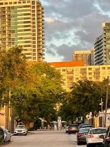 a city street with cars parked in front of tall buildings at Nice Queen Bedroom - Best Location in Miami - Luggage Storage Service, Parking and Laundry for free!!!! in Miami