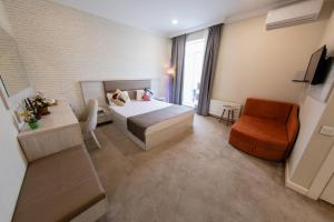 a bedroom with a bed and a desk and a chair at Zimmer Boutique Hotel in Baku