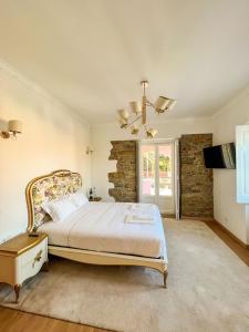 um quarto com uma cama king-size e uma parede de pedra em Chalet do Eléctrico 92' em Sintra