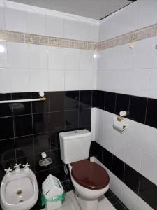 La salle de bains en noir et blanc est pourvue de toilettes et d'un bidet. dans l'établissement Temporariolashermanas, à Reconquista