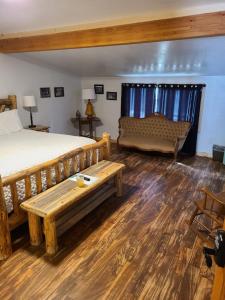 a bedroom with a bed and a bench and a couch at The Gold Mine Hotel in Idaho City +5 photos