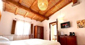 una camera con letto e soffitto in legno di Agriturismo Li Scopi a San Teodoro