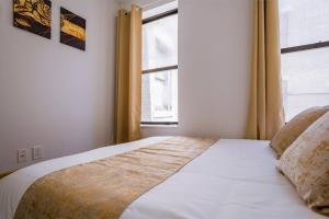 A bed or beds in a room at 5-Bedroom NYC Apartment