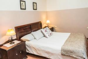 um quarto com uma cama e uma mesa de cabeceira com um candeeiro em Pozuelo 2 JABUGO em Jabugo