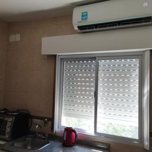 una finestra della cucina con tende sul lavandino di Monoambiente Moderno. a Santiago del Estero