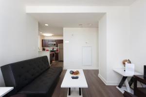 a living room with a black couch and a table at Fantastic Philly Fully Furnished Apartments in Philadelphia